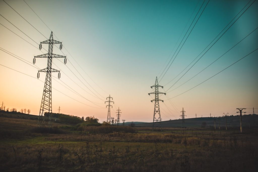 landscape photography of electric towers under a calm blue sky